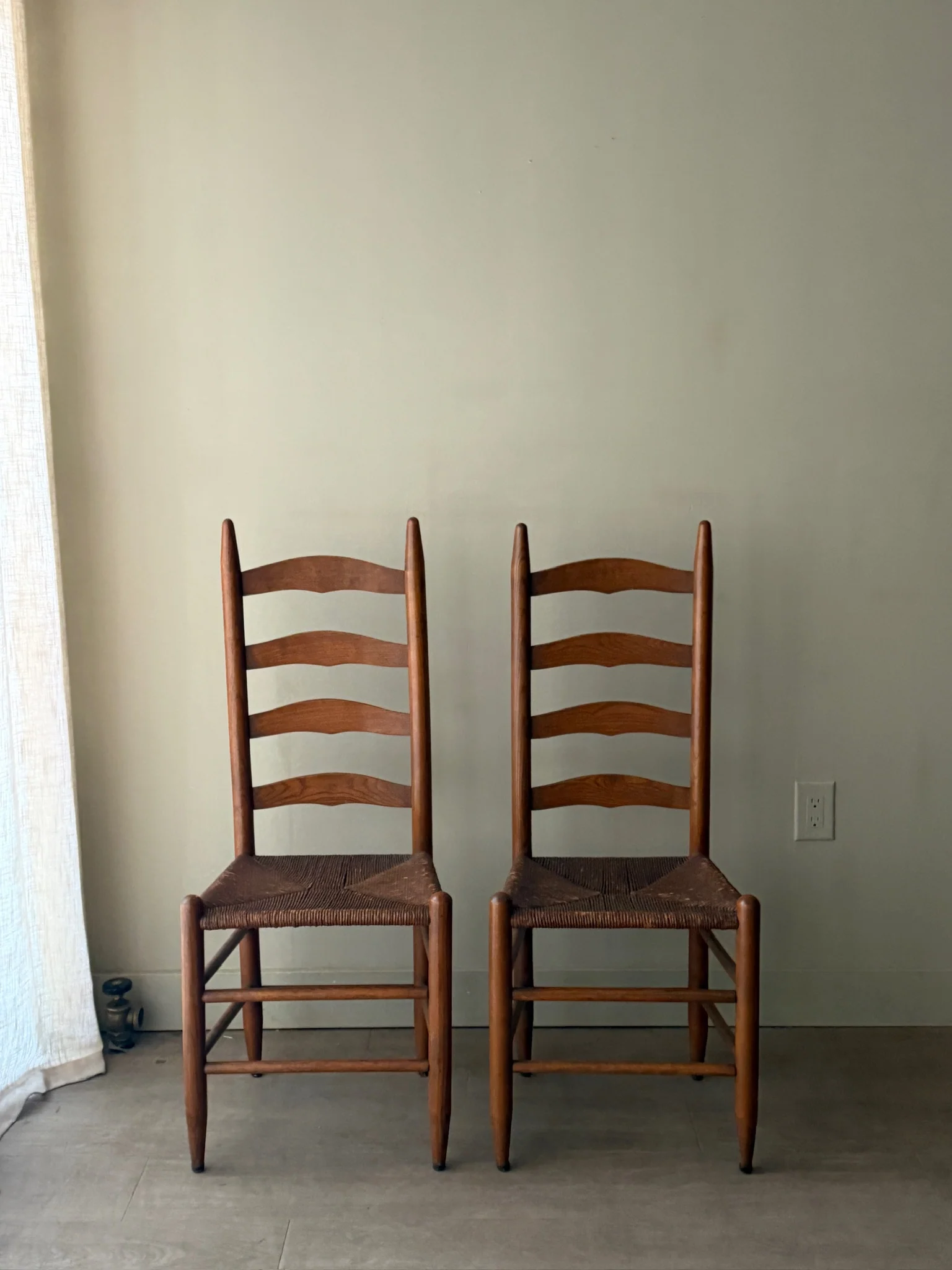Oak ladder back rush seat dining chairs. Sold as a pair.